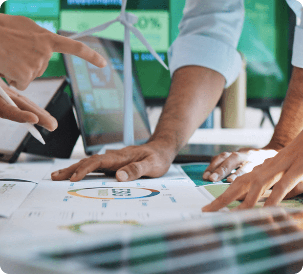 Hands pointing at business charts on table.